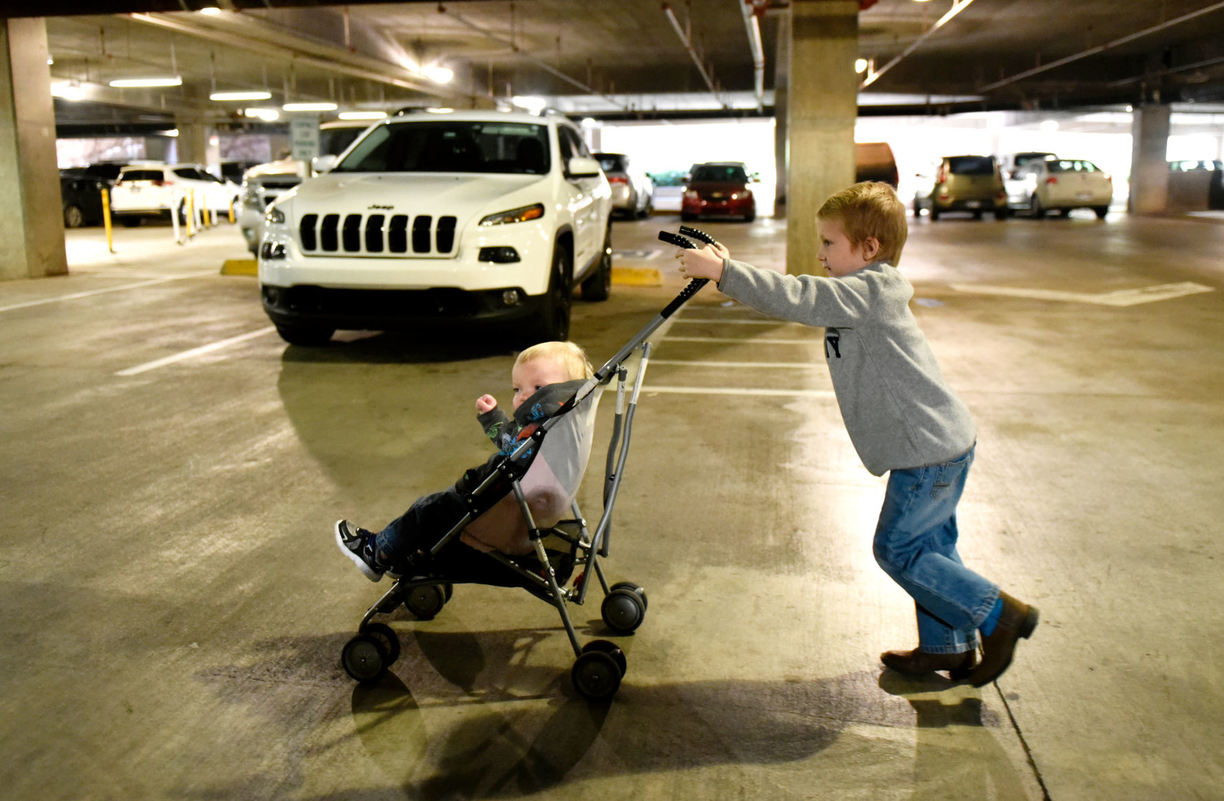 Stephanie Oakley's son pushes his brother in a stroller as they arrive for his chemotherapy at Children's Hospital in Oklahoma City